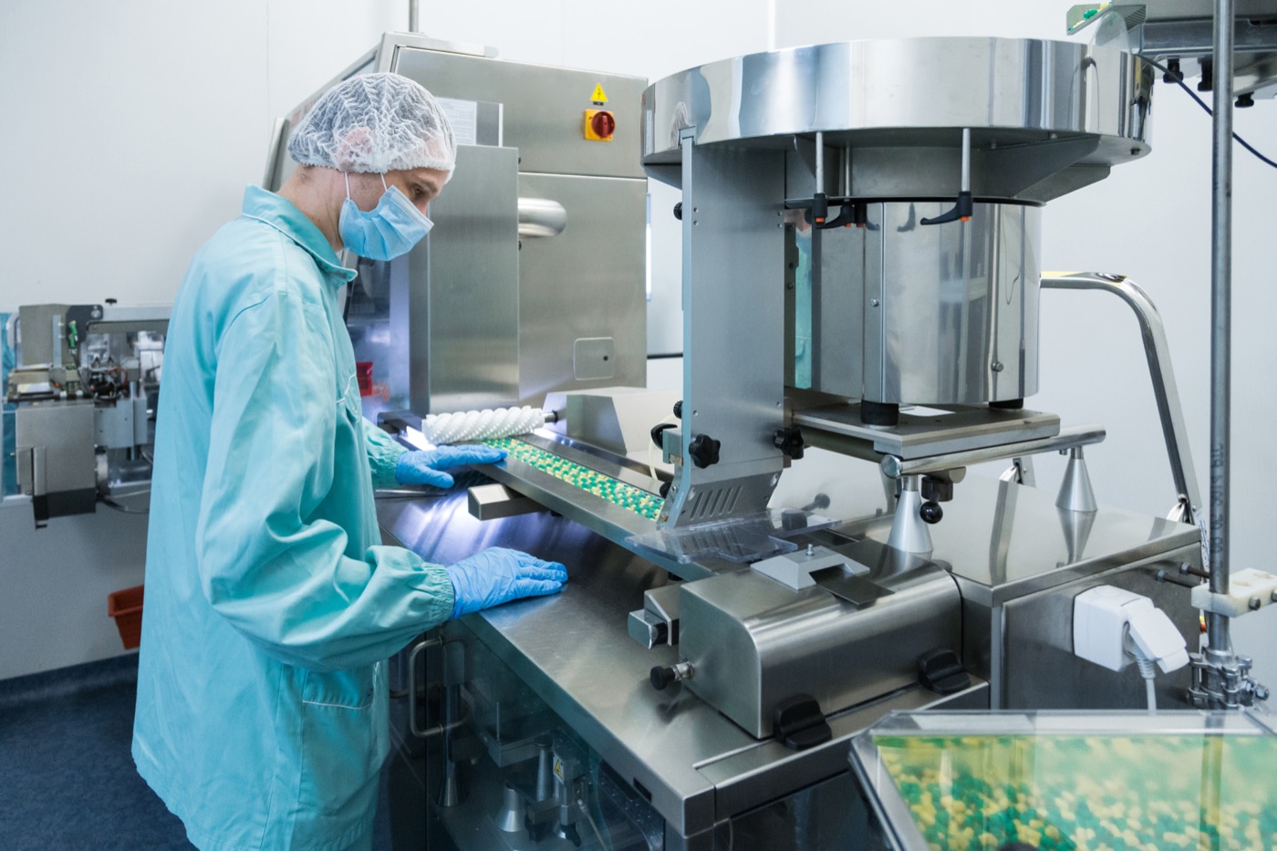 Technician operating supplement production equipment